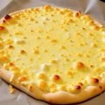 cottage cheese pizza crust, bubbly cheese topping and a thick, hand-rolled crust, resting on parchment paper.