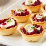 Crispy phyllo cups filled with creamy goat cheese and topped with cranberries, perfect for Thanksgiving.